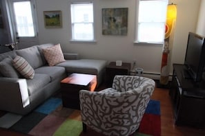 Side view of living room; great light; hint of the artwork throughout