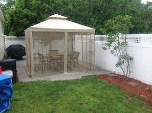Gazebo, enclosed, with seating for 6. The BBQ w/ herb garden/veggies coming.