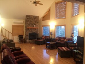 Main Living Room with wood burning fireplace. Open to kitchen and dining areas.