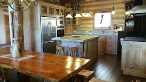 Kitchen and dining area.  Stainless steel appliances & handcrafted dining table.