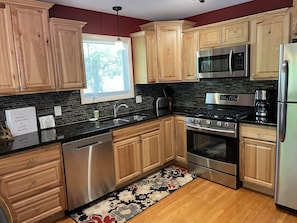 Renovated kitchen with rustic hickory cabinets and modern stainless appliances.