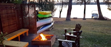 Relaxing fire pit by the lake along with canoes and kayaks for guests use