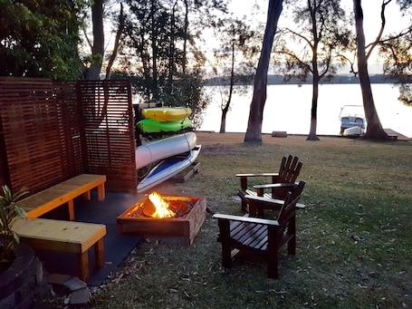 Relaxing fire pit by the lake along with canoes and kayaks for guests use