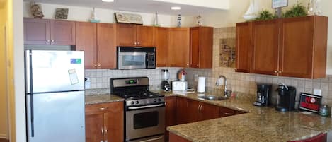 Stainless Kitchen, granite counters, tile floor and decorative art