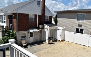 Side view of house with grill and outside shower
