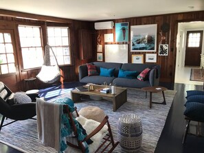 Living room with view of back yard across entire back wall.