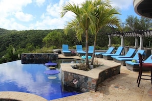 Island Stones pool deck has 8 chaise lounges, tables & chairs, & shaded trellis