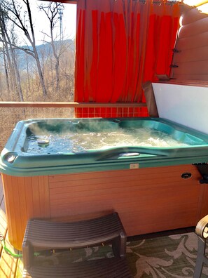 Hot tub with custom outdoor curtains to add privacy and shade.
