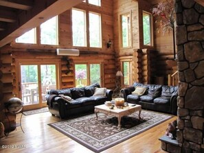 Spectacular Living Room With Stone Fireplace and pond views.