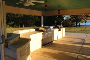 Propane grill and a smoker located in patio.  Large counter for serving.