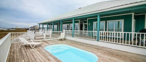 Pool deck and back deck leads down to waterfront with pier
