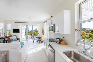 Unwind in the expansive living room and kitchen area of our residence, featuring a charming dining area that invites you to savor meals while delighting in the panoramic ocean view from the balcony