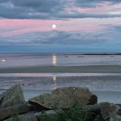 Amazing deck view of the moon over the beach.