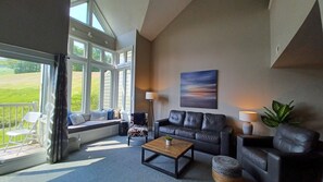 The sun filled spacious living room has vaulted ceilings and a window bench.