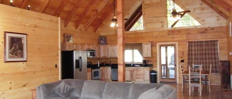 Great room with exposed beams, hickory floors and a nice sectional sofa to relax