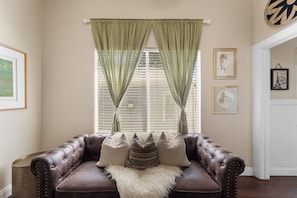Relax in our cozy couch in the living room with plenty of natural light