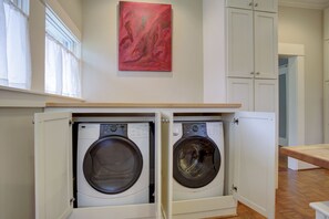 Full sized front loading washer and dryer in kitchen. Hidden in cabinets.