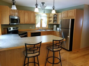 Kitchen with all appliances, including dishes, utensils, pots and pans. 