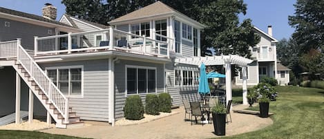 Beautiful patio with pergola and upper deck facing the water