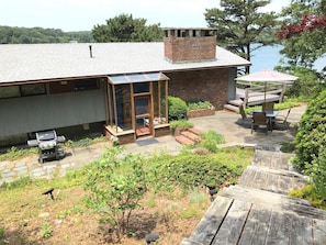 Front entry with gas grill (L) patio table (R), and Lagoon Pond in background.