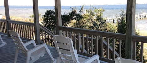 Wraparound porch rocking chairs, captains chairs, picnic table overlooking sea.