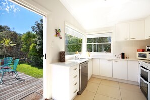 Modern, Well equipped kitchen opens onto back deck