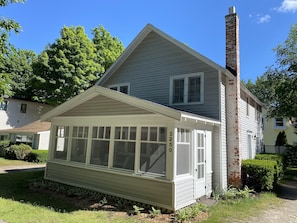 Front of cottage screened in porch.