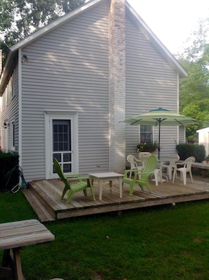 Rear of the cottae with large deck and lots of setting.  Umbrella and bar-b-que.