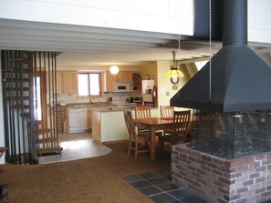 Center fireplace with view of kitchen and dining area.