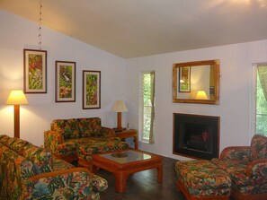 Tropical Themed Living Room with original prints by Garry Palm and Electric Fireplace. Perfect for relaxing with family and friends.