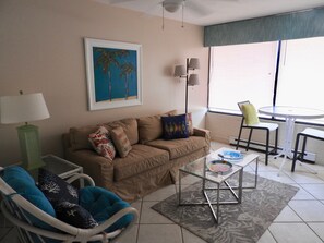 Tan slip covered sofa, Dinette with 2 tall chairs.
