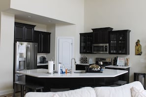 Gourmet kitchen - upgraded appliances, quartz countertops, well-stocked.