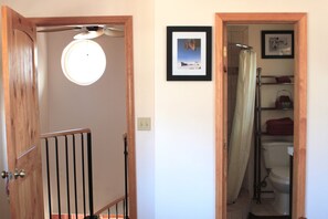 upstairs bathroom with shower and spiral stairs downstairs