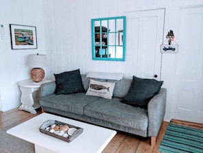 Nicely decorated, roomy living room. The couch is a sleep sofa.