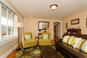 LIVING ROOM - Ottoman seat stocks comfy blankets, bookcase w/ plenty of books