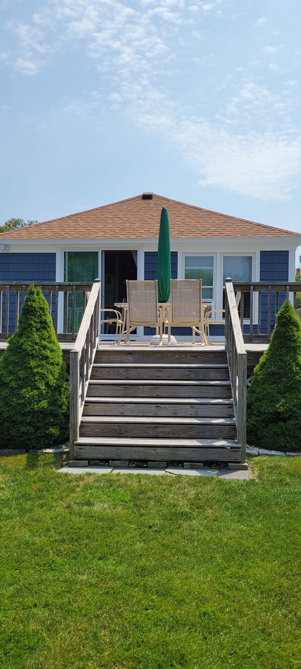 Cottage with view to huge deck from back yard.