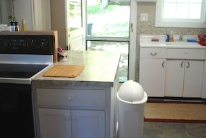 A fullsize glasstop stove, microwave, vintage sink, side-by-side regfrigerator.