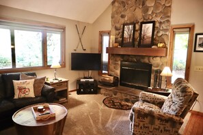 Cozy living room with wood burning fireplace and plenty of natural light. 