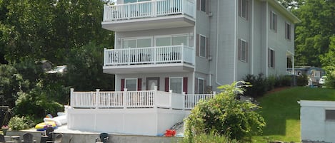 View of house from lakeside with fire pit on beach