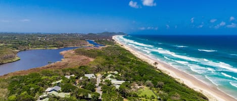 Looking north along Tallow Beach to Cape Byron Lighthouse and Byron township