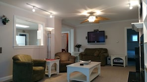 Living Room with pass-through window, plasma TV, loveseat twin sleeper below TV.