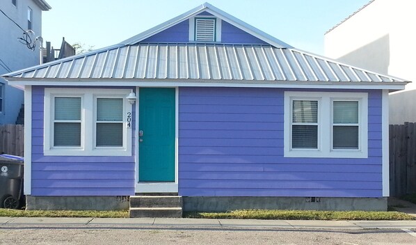 Cute purple cottage with recent siding, roof and AC unit.