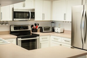 Kitchen with stainless appliances overlooking living and dining rooms
