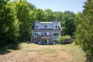 Back of House with large backyard that slopes gently to the beach.