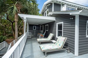 Partially covered front porch. 2 loungers, 2 rocking chairs.