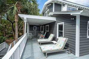 Partially covered front porch. 2 loungers, 2 rocking chairs.