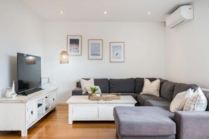 Lounge with large couch and Smart TV