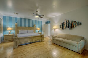 Contemporary primary suite has a king bed, queen sofa, smart TV and large walk-in closet.