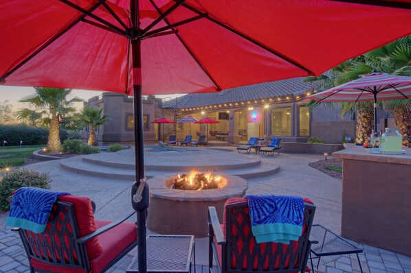 Enjoy the glow and warmth from the gas fire pit or wood burning fireplace in the backyard paradise at MESA DESERT OASIS.