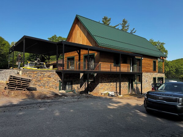 Street side showing carport and main entrance via covered footbridge. 